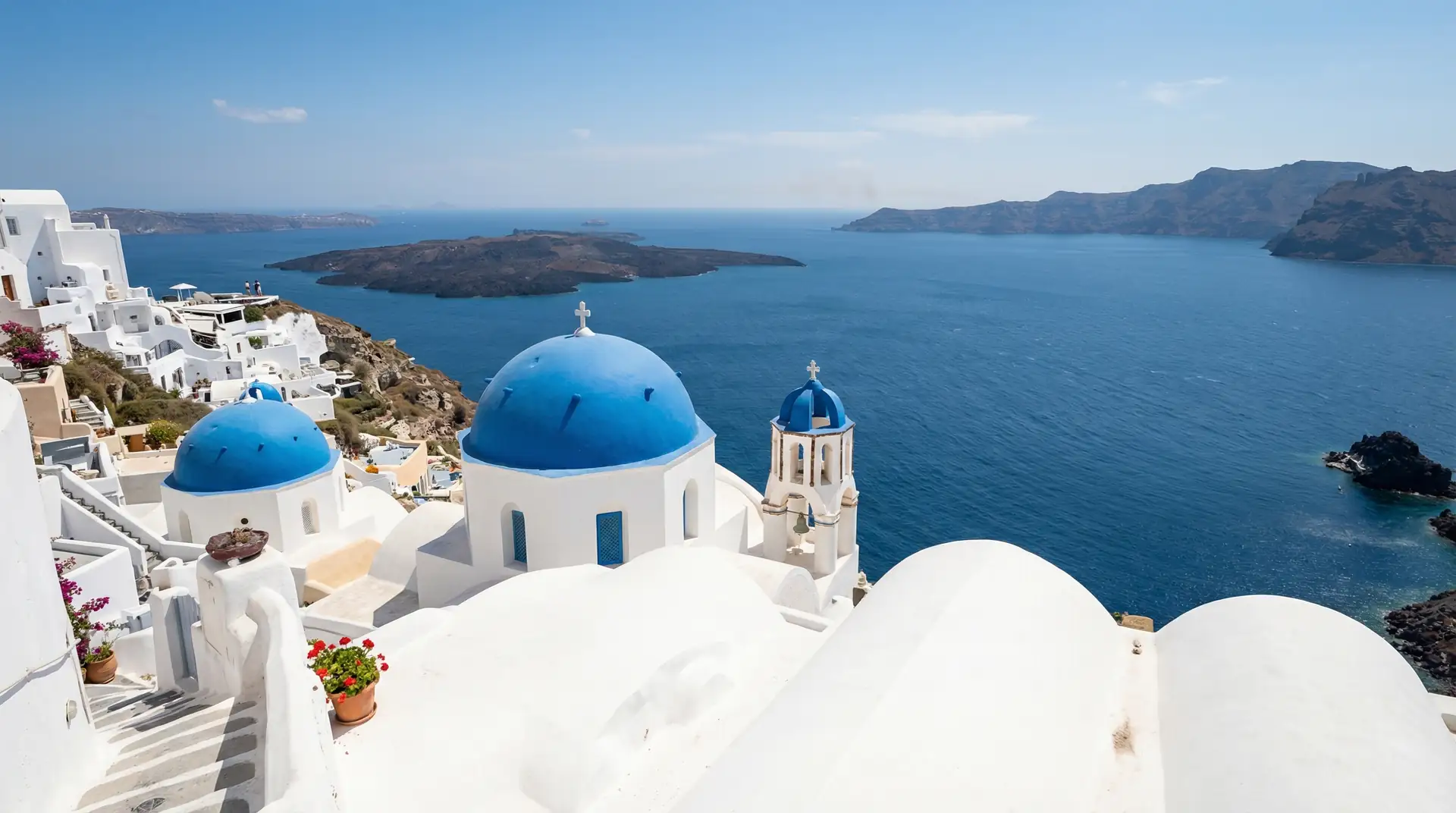 Santorini white-washed buildings with blue domes overlooking the Aegean Sea in Greece — OraVisa Greece visa services from Dubai